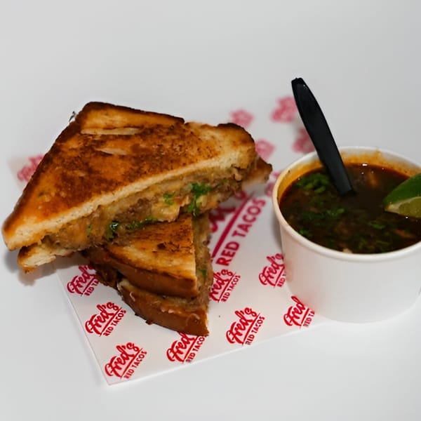 Fred's Red Tacos grilled cheese sandwich with a side of birria consommé.